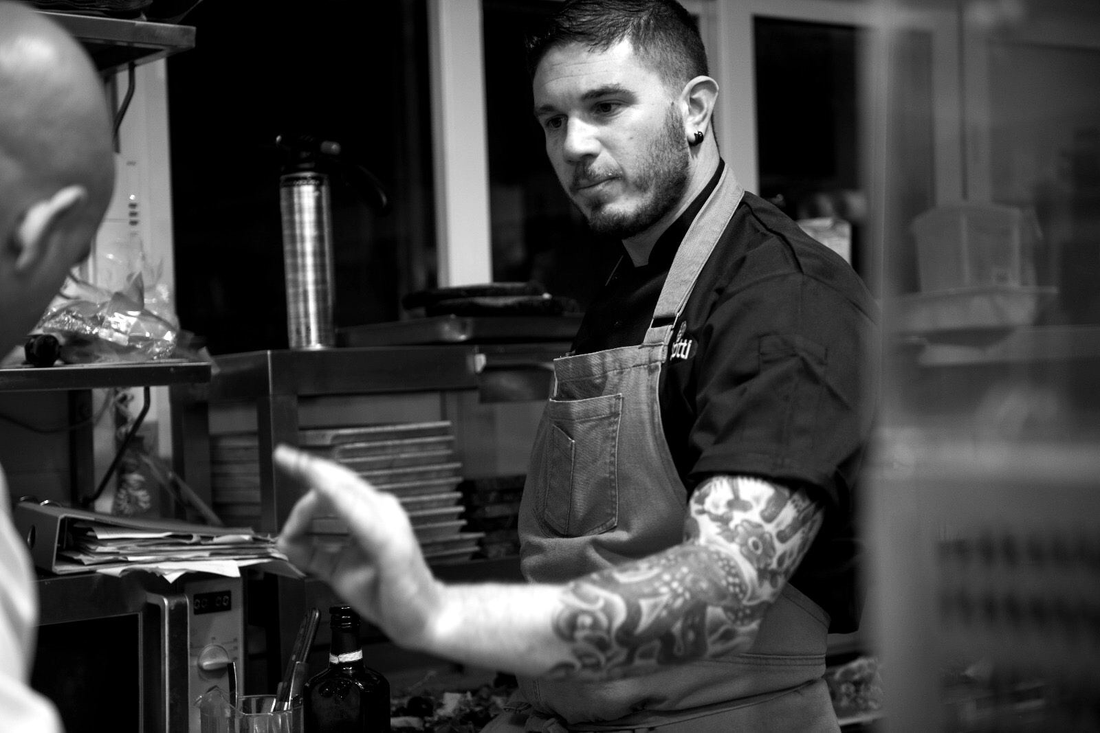 Sean Gravina briefing a colleague in a busy kitchen